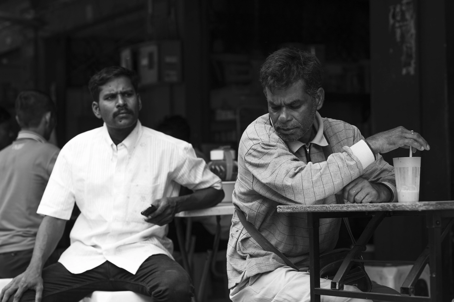 Two men at a roadside cafe in Brickfields, Kuala Lumpur, Malaysia.